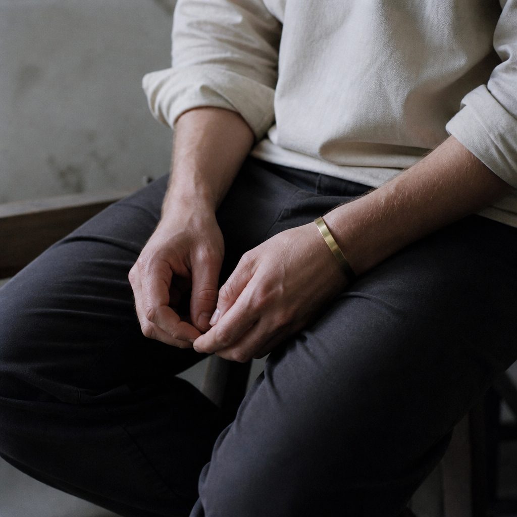 A person seated, listening, hands folded