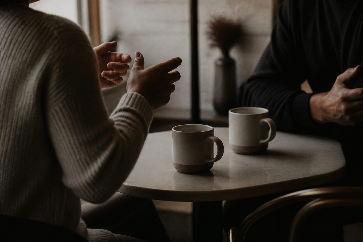 Two people talking over coffee