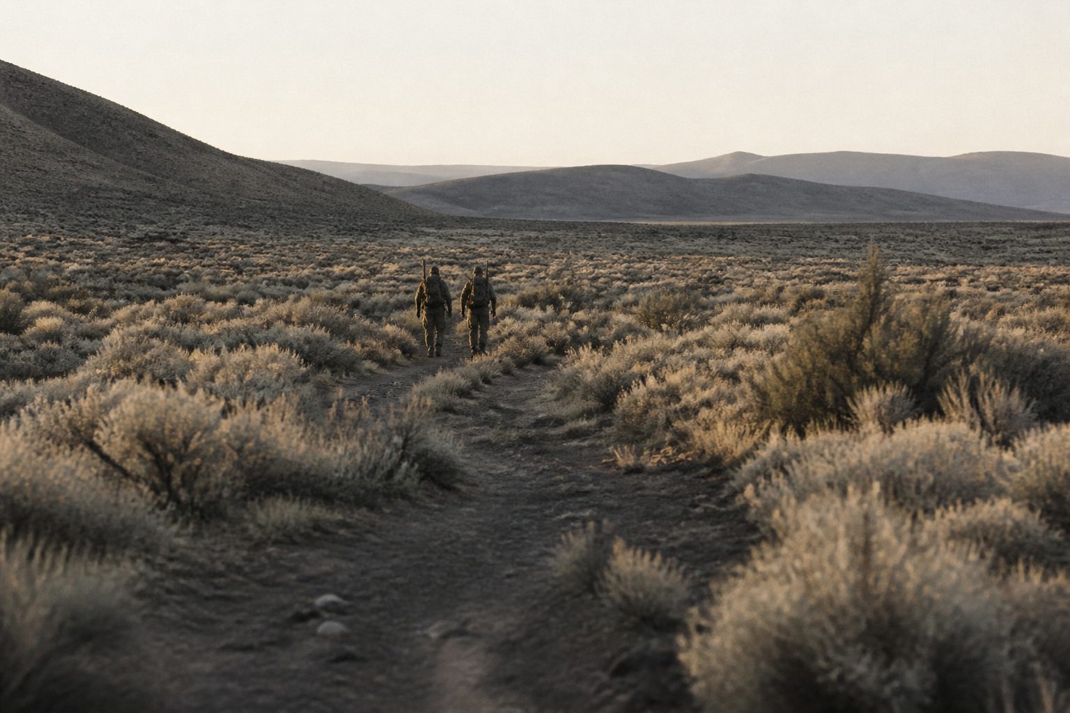 Two figures walking a trail